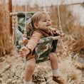 Load image into Gallery viewer, baby using outdoor baby swing shown in tropical leaf fabric for outdoor playtime