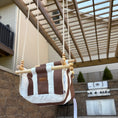 Load image into Gallery viewer, Brown and white striped swing hanging outdoors on a patio