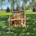Load image into Gallery viewer, Nature-inspired baby swing hanging outside with nutmeg leaf fabric, shown with 2 pillows