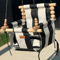 Load image into Gallery viewer, Side view of wide black striped pattern outdoor high back baby swing with beautiful maple wood dowels and black twisted rope