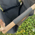 Load image into Gallery viewer, Close-up of a wooden handle with gray colored swing on a chair, blurred green background