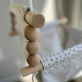 Load image into Gallery viewer, Close up of natural wood beads and dowels on neutral confetti high back swing
