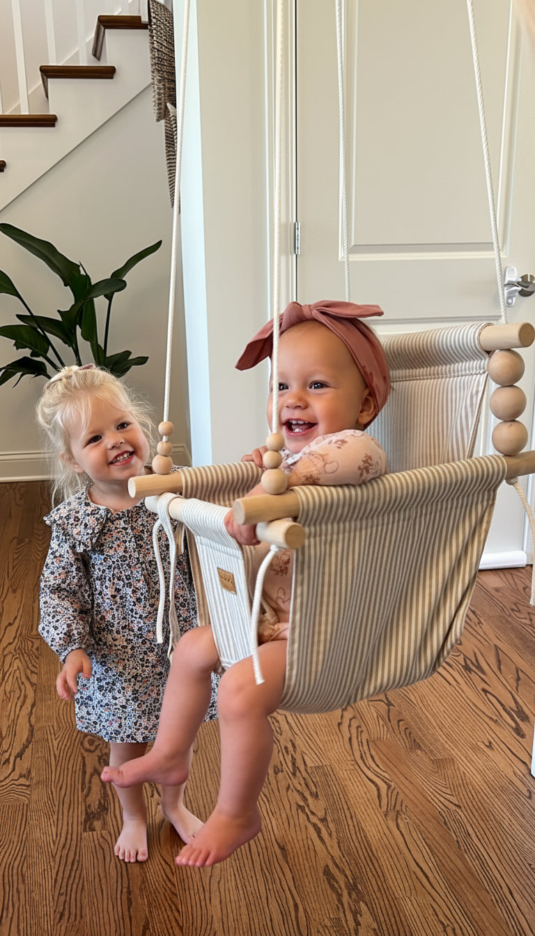 Two children standing on a wooden floor playing in a swing