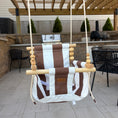 Load image into Gallery viewer, Brown and white striped chair swing hanging from a wooden pergola in an outdoor setting.
