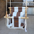 Brown and white striped swing chair hanging outdoors on a patio.