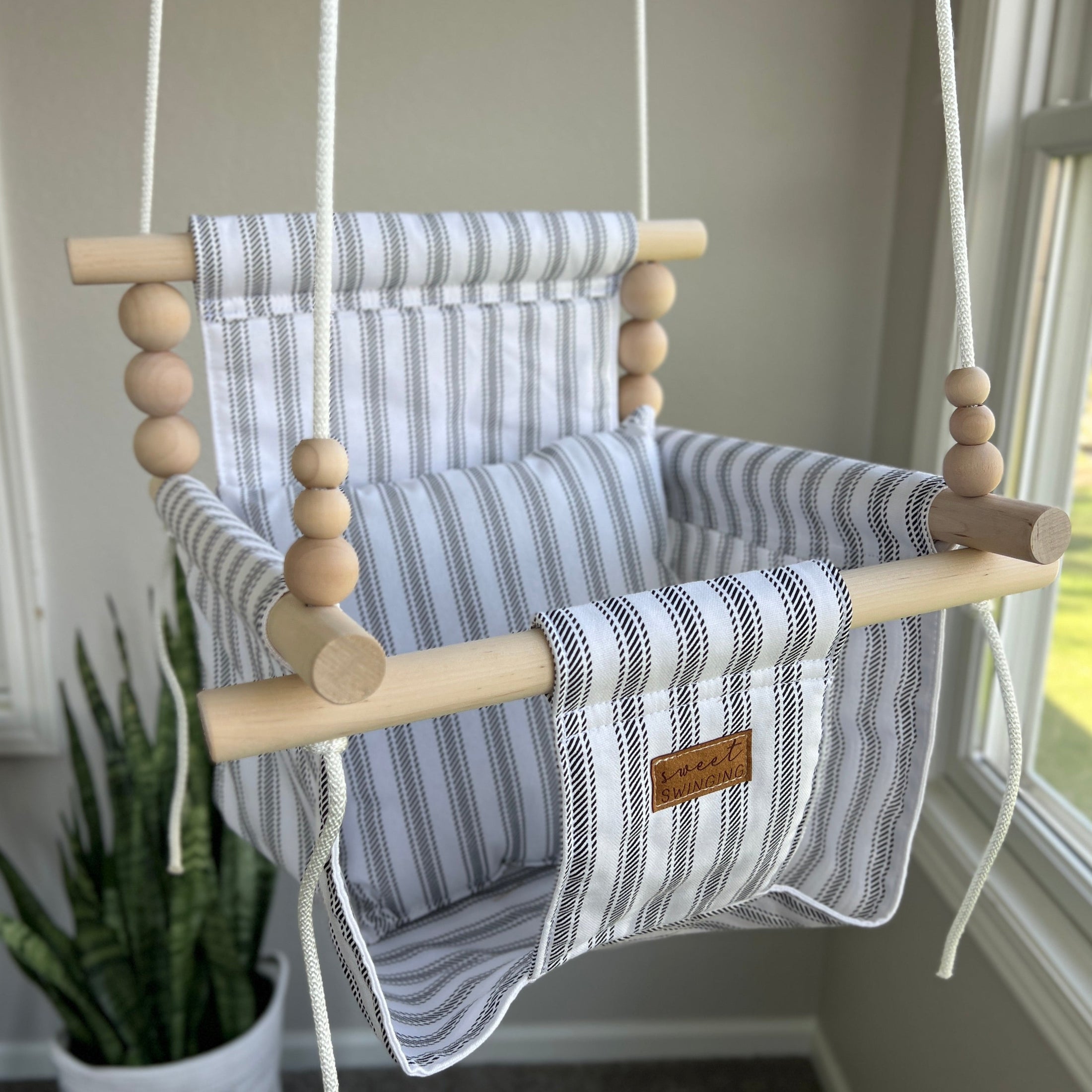 Wide ticking stripe baby swing in classic neutral tones, high back indoor design